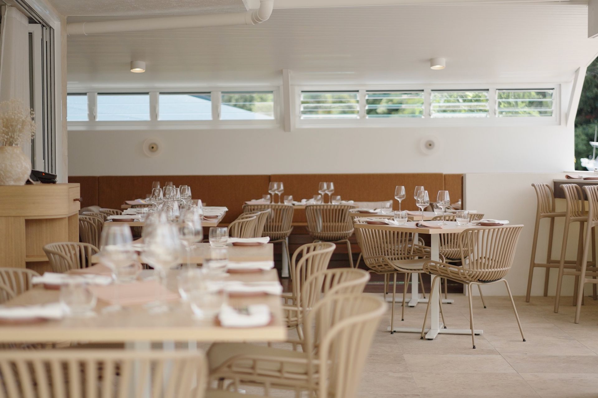 Dining area with timber chairs, tables and natural light
