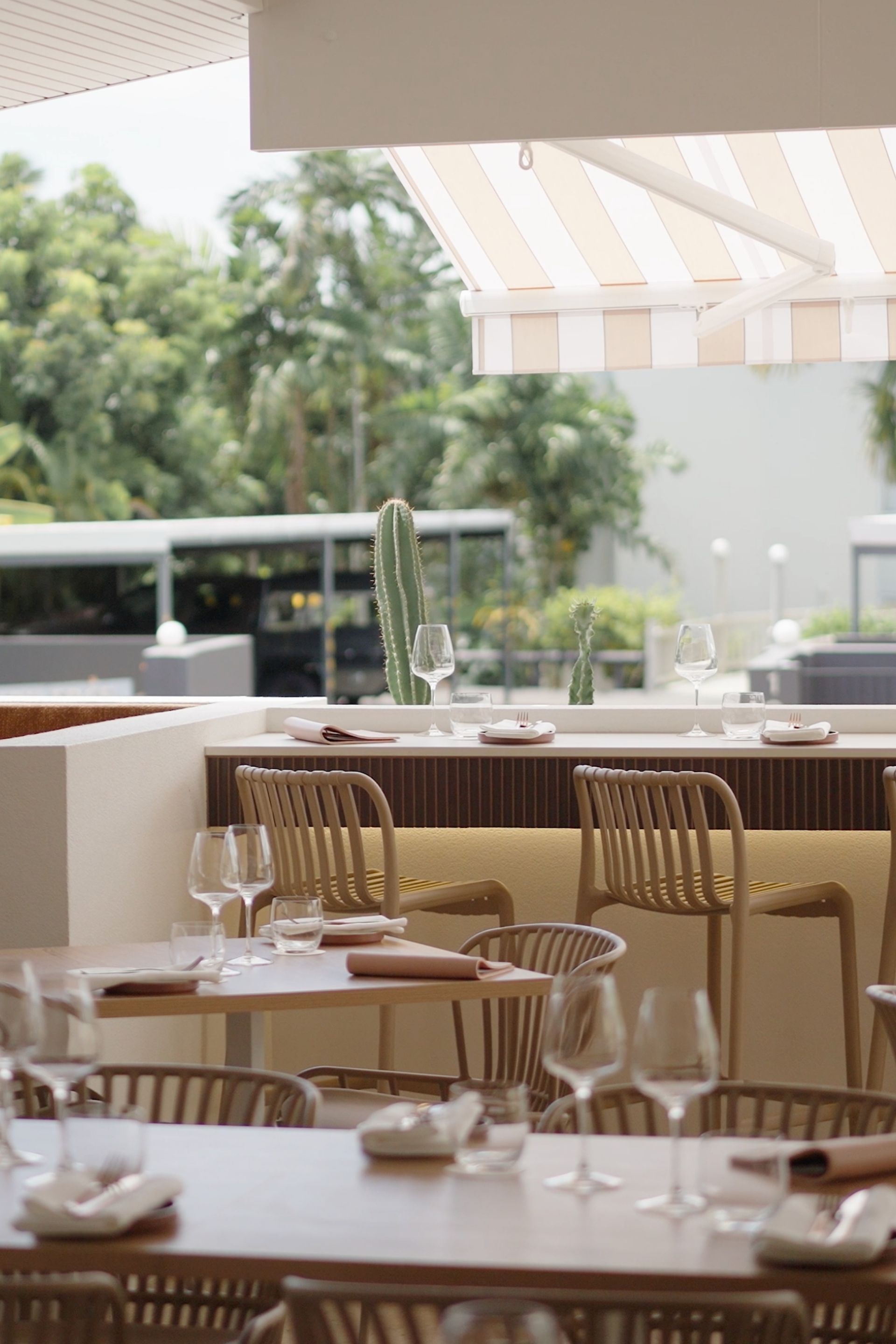 View of alfresco terrace dining area with high bar tools and table facing Collins Avenue