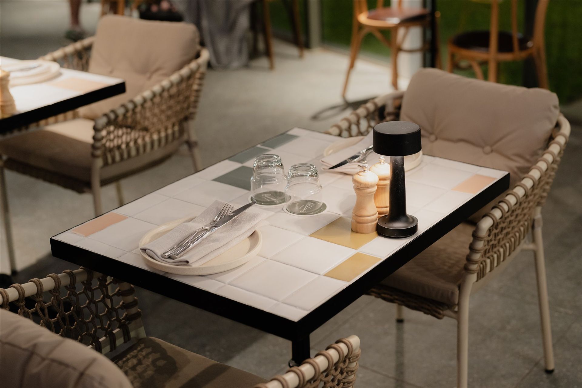 Dining table detail with tiled surface and soft, ambient lighting