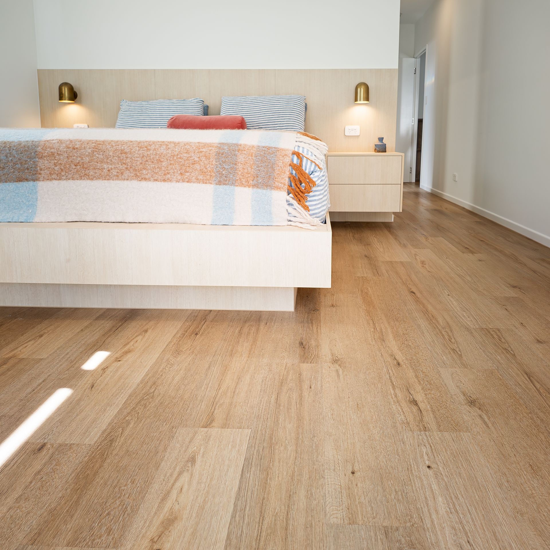 Bedroom with timber flooring, soft textiles and natural light