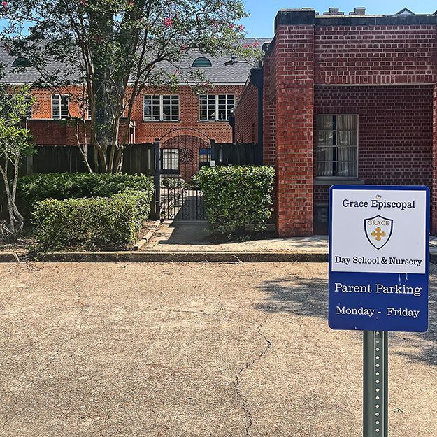 A brick house with cars parked in front of it