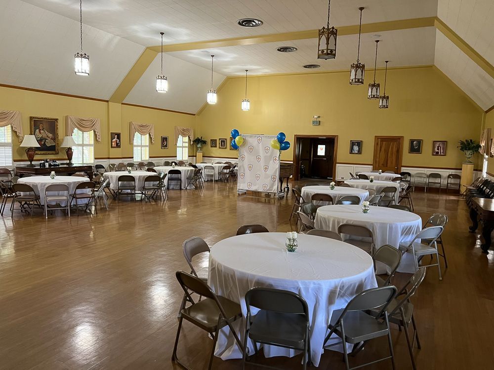 A large room with tables and chairs set up for a party.