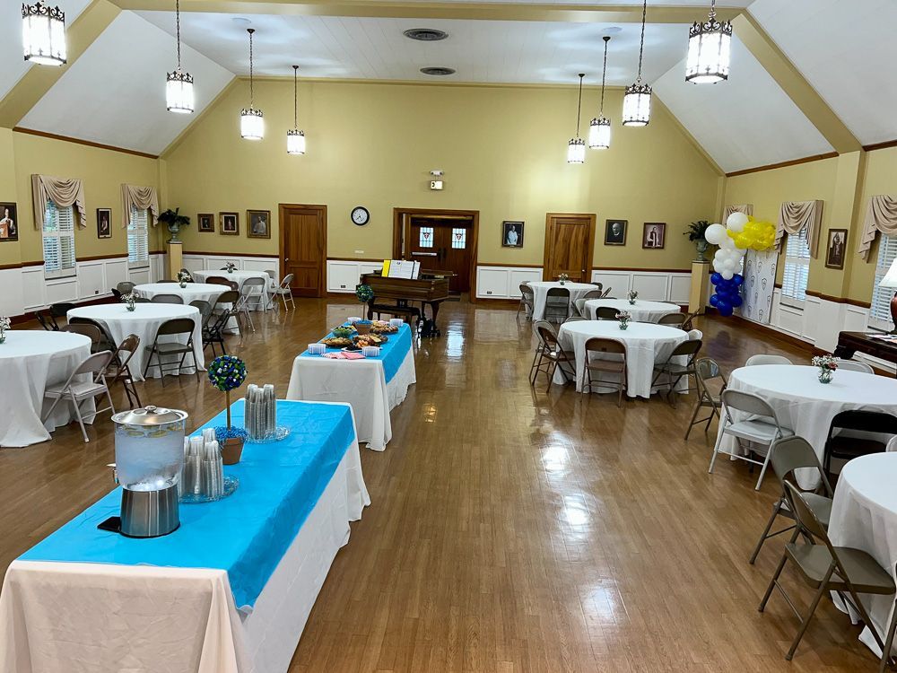 A large room with tables and chairs set up for a party.
