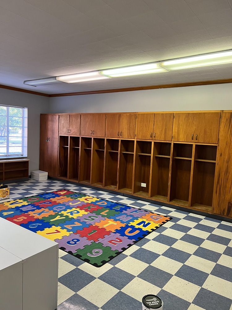 There is a colorful rug on the floor in the locker room.