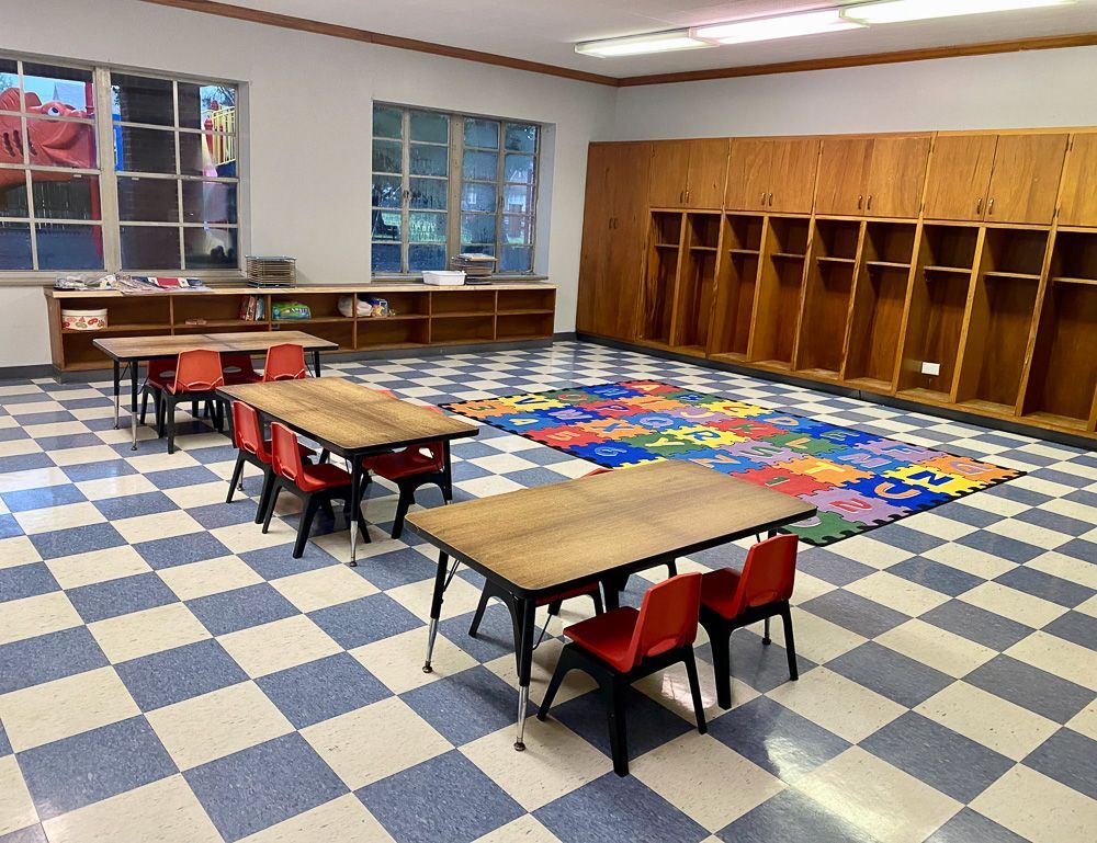 A room with tables and chairs and a checkered floor