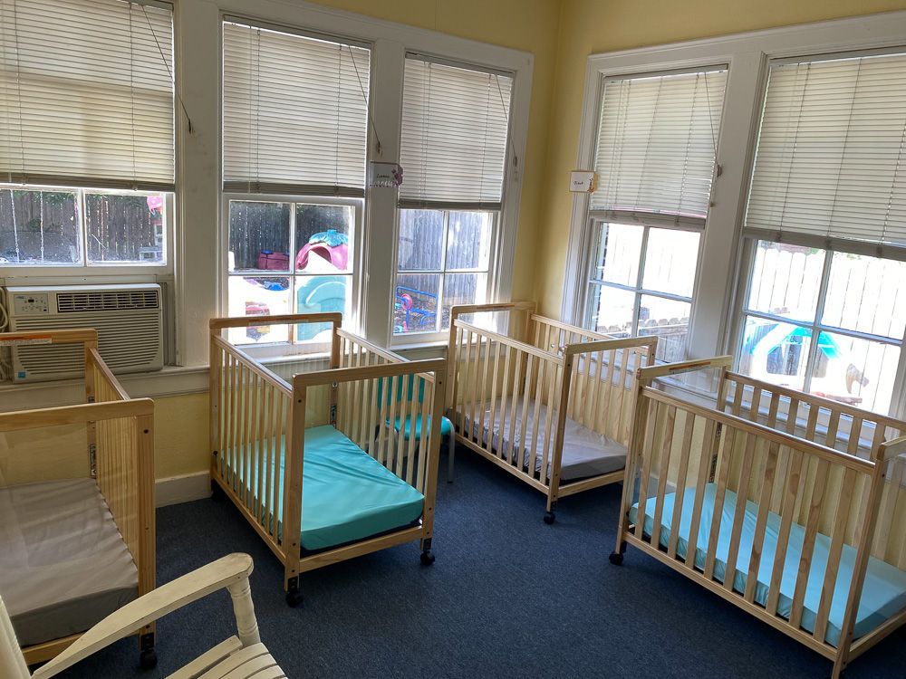 A room filled with cribs and a rocking chair.