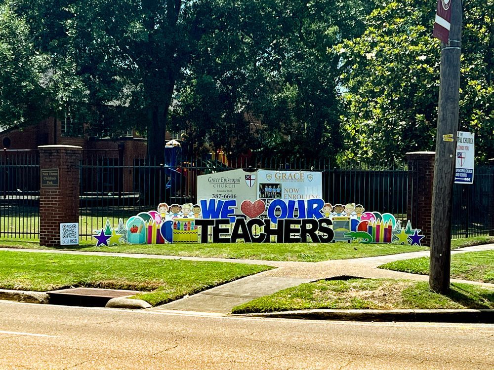 A sign that says `` we love our teachers '' is in front of a school.