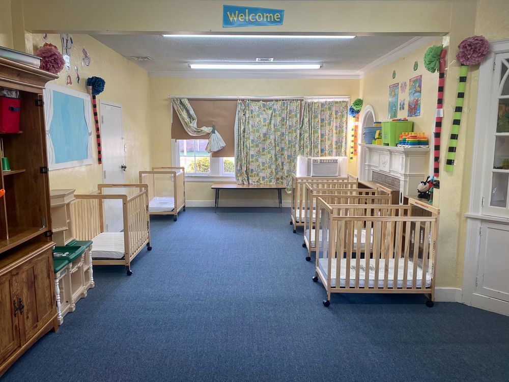 A room with cribs and a sign that says welcome