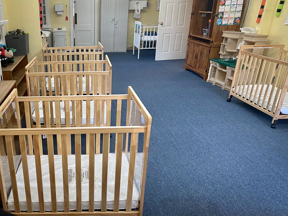A room filled with cribs and a changing table.
