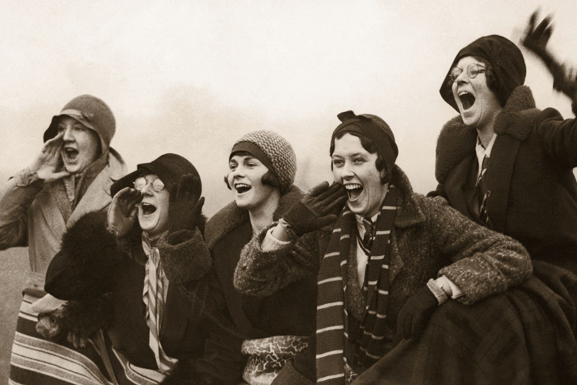a black and white photo of a group of women laughing