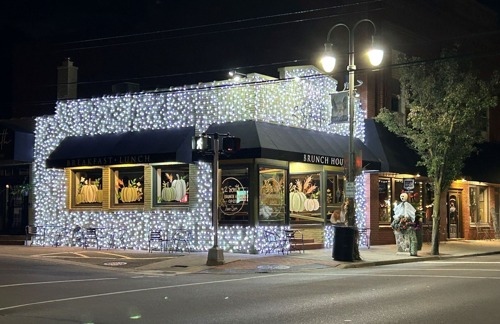 A building with christmas lights on it is lit up at night.