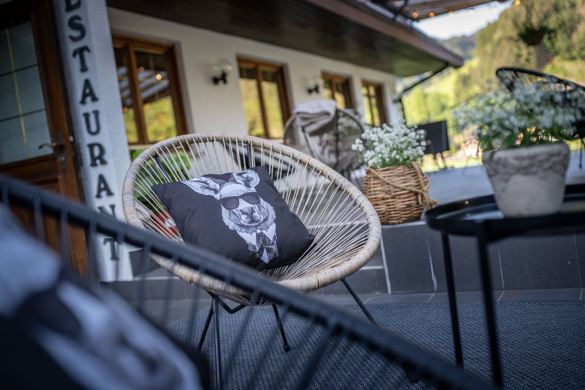 A chair with a pillow on it is sitting in front of a restaurant.