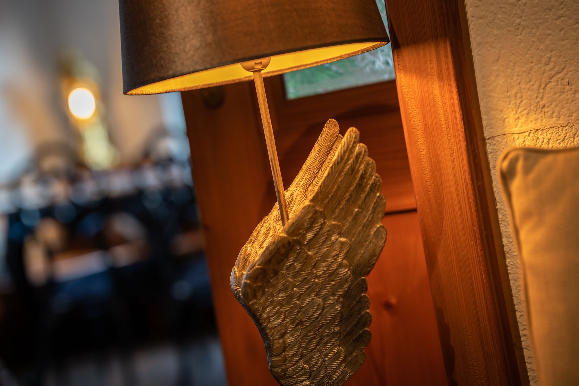 A lamp is sitting on a wooden door next to a couch.