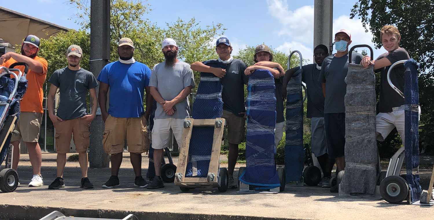 A group of men are standing next to each other on a sidewalk.