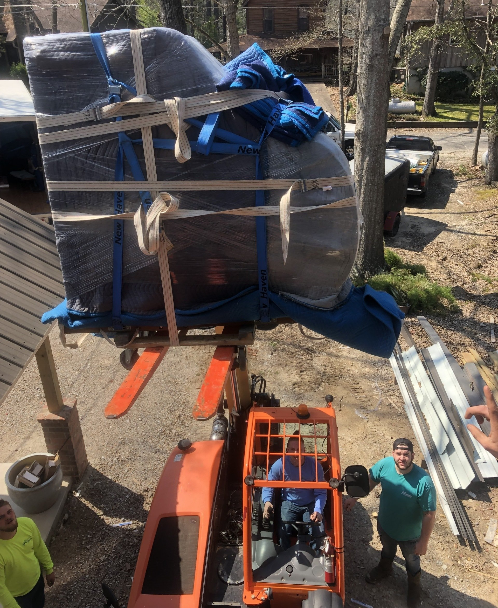 jr brown employees lifting piano into moving truck