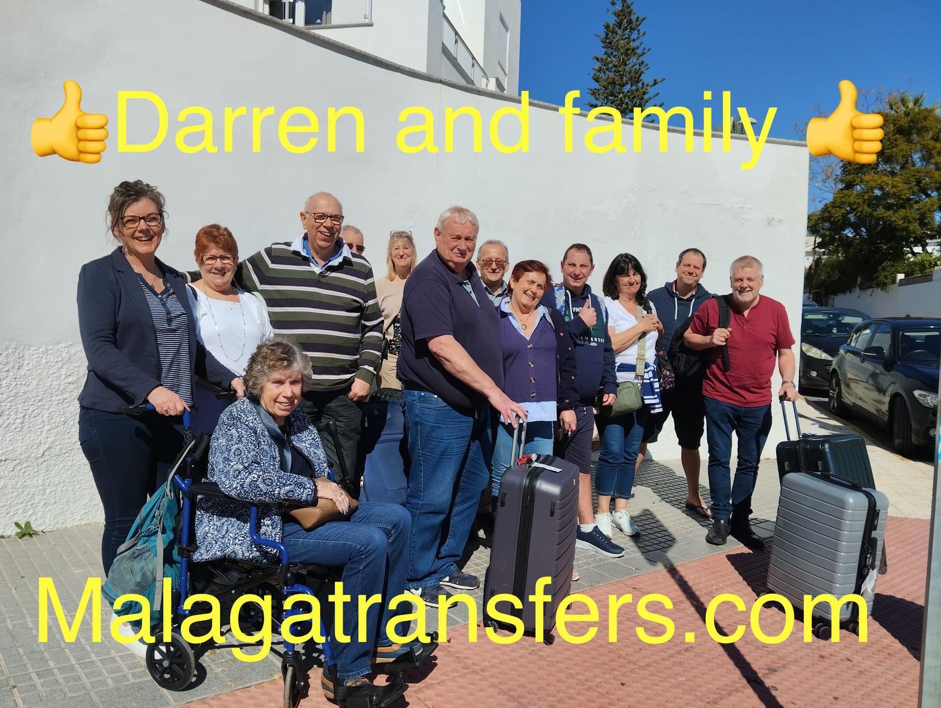 A group of people posing for a picture with the website malagatransfers.com