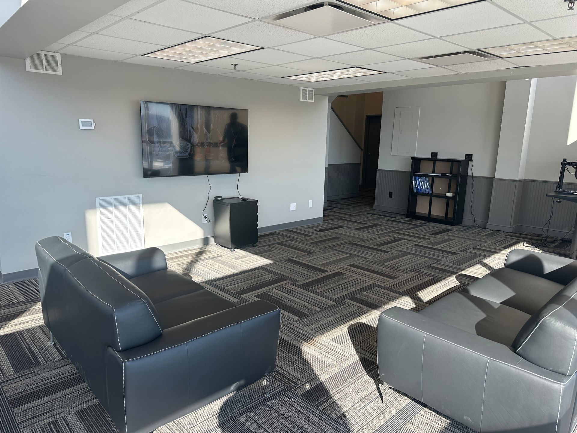 A living room with a couch , chairs and a flat screen tv.