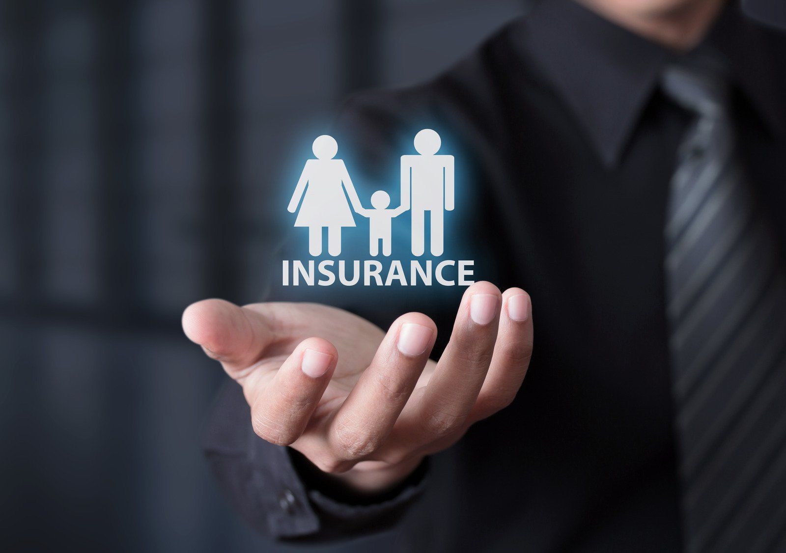 Person holding a glowing insurance icon of a family.