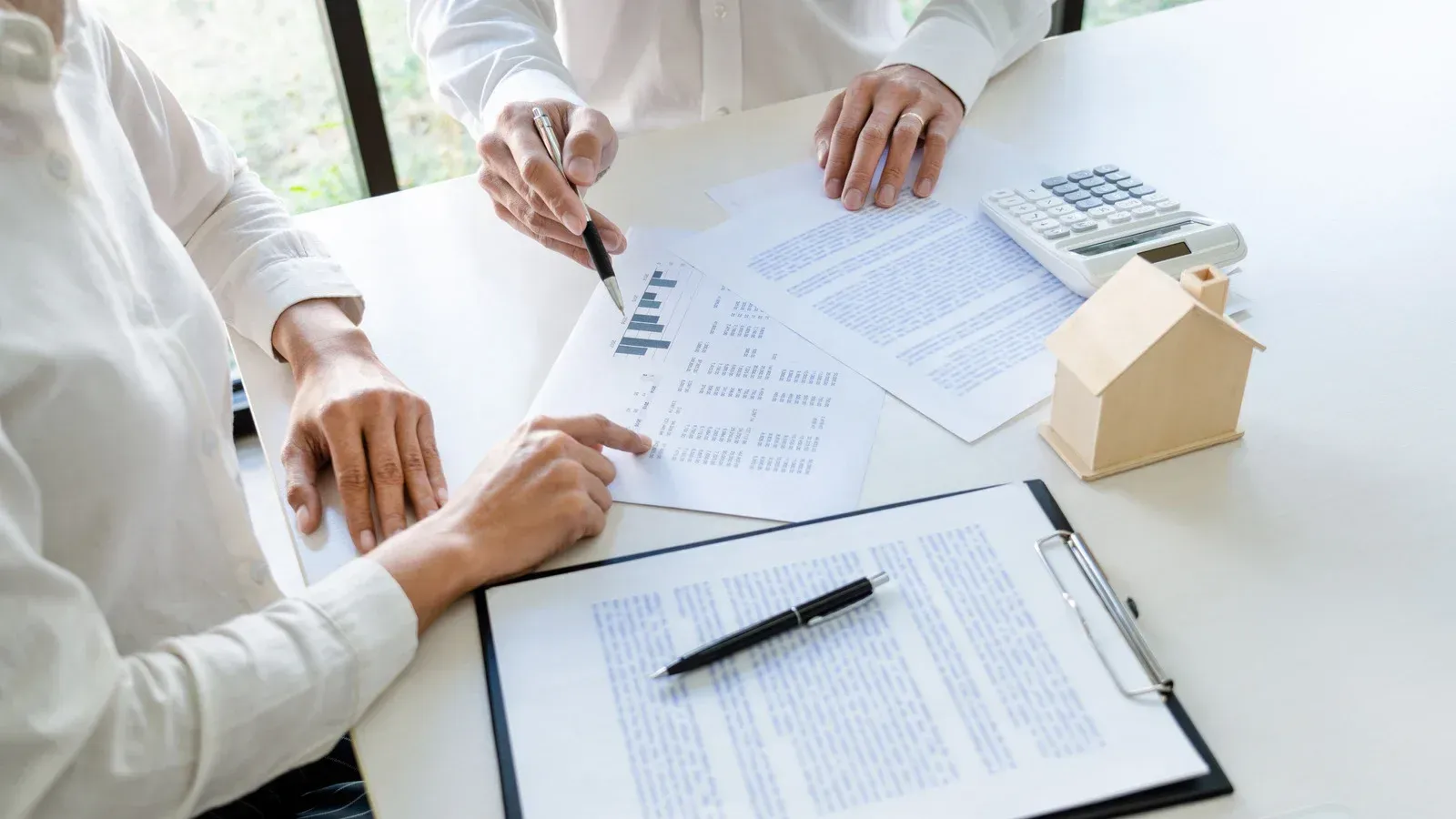 A man and a woman are sitting at a table looking at papers.