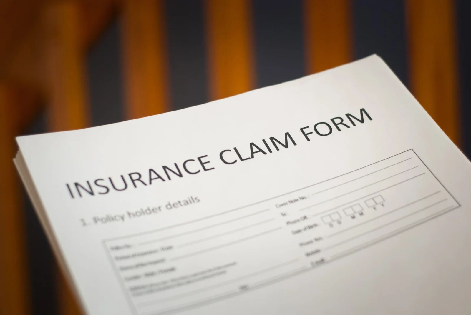 Insurance claim form on a white sheet with a blurred background.