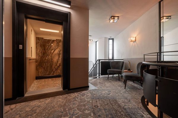 Een hotelkamer met twee bedden en een schilderij aan de muur.