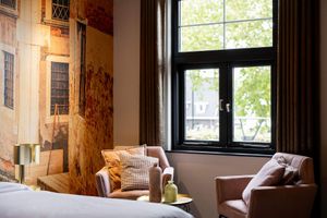 Een hotelkamer met een eenpersoonsbed en een foto van de skyline van een stad aan de muur.