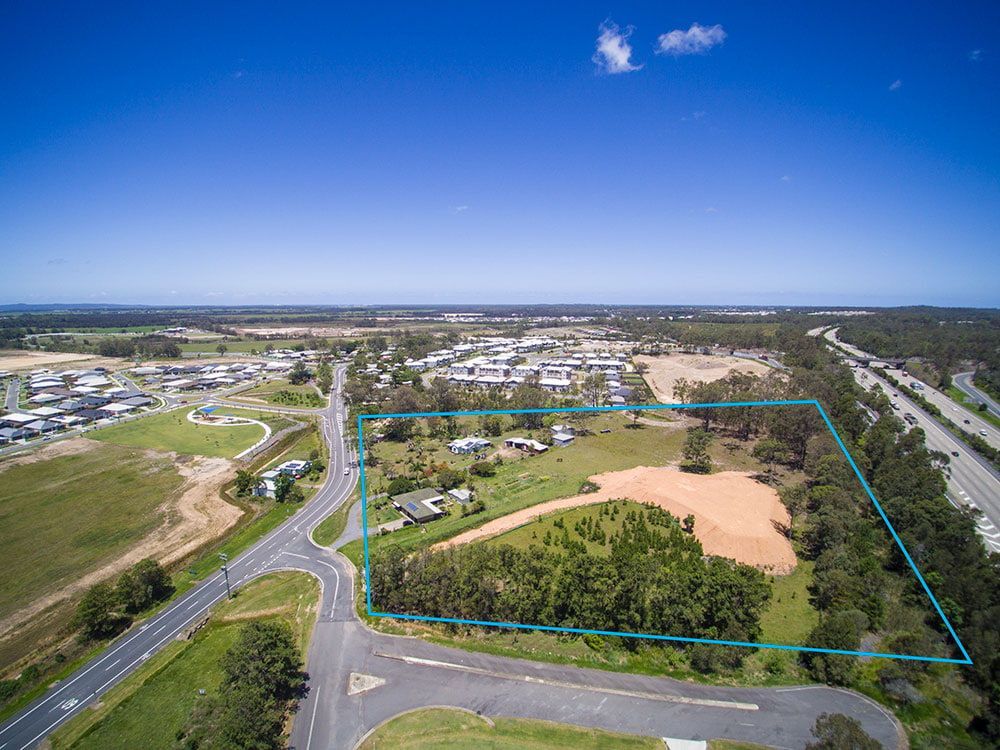 An Aerial View Of A Residential Area Surrounded By Trees And A Road β Harrison Development Group In Surfers Paradise, QLD