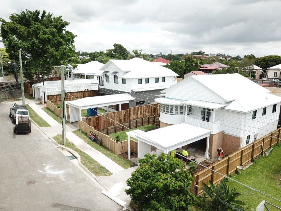 An Aerial View Of A Row Of White Houses On A Residential Street — Harrison Development Group In Surfers Paradise, QLD