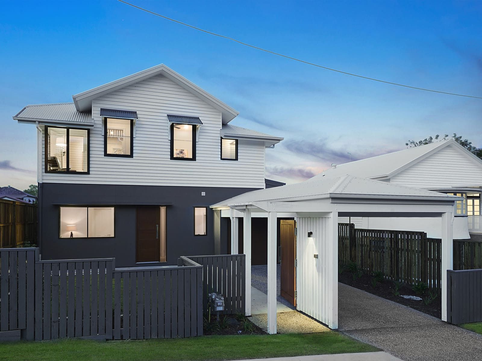 A Black And White House With A Fence In Front Of It β Harrison Development Group In Surfers Paradise, QLD