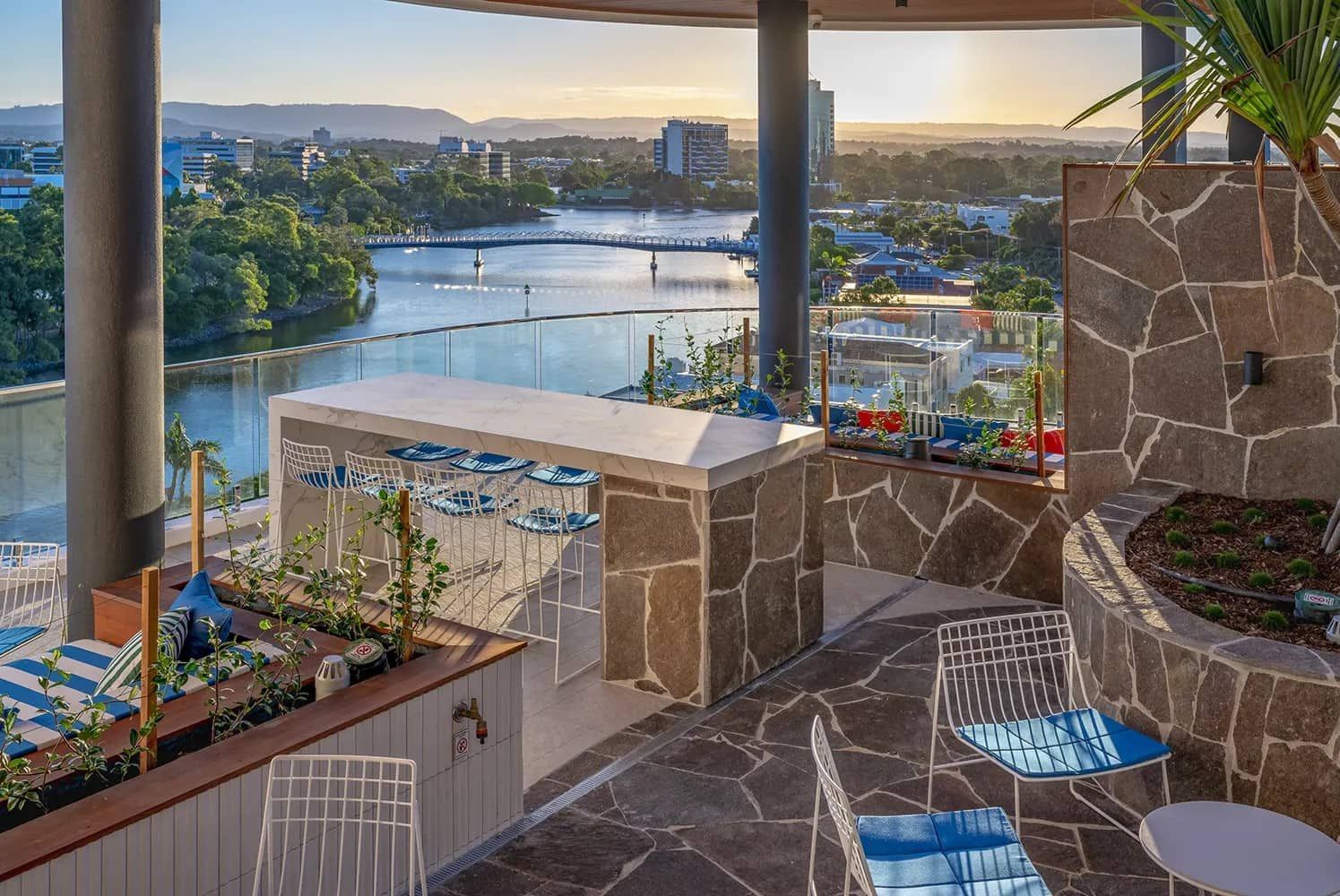 A Balcony With Tables And Chairs Overlooking A Body Of Water — Harrison Development Group In Surfers Paradise, QLD