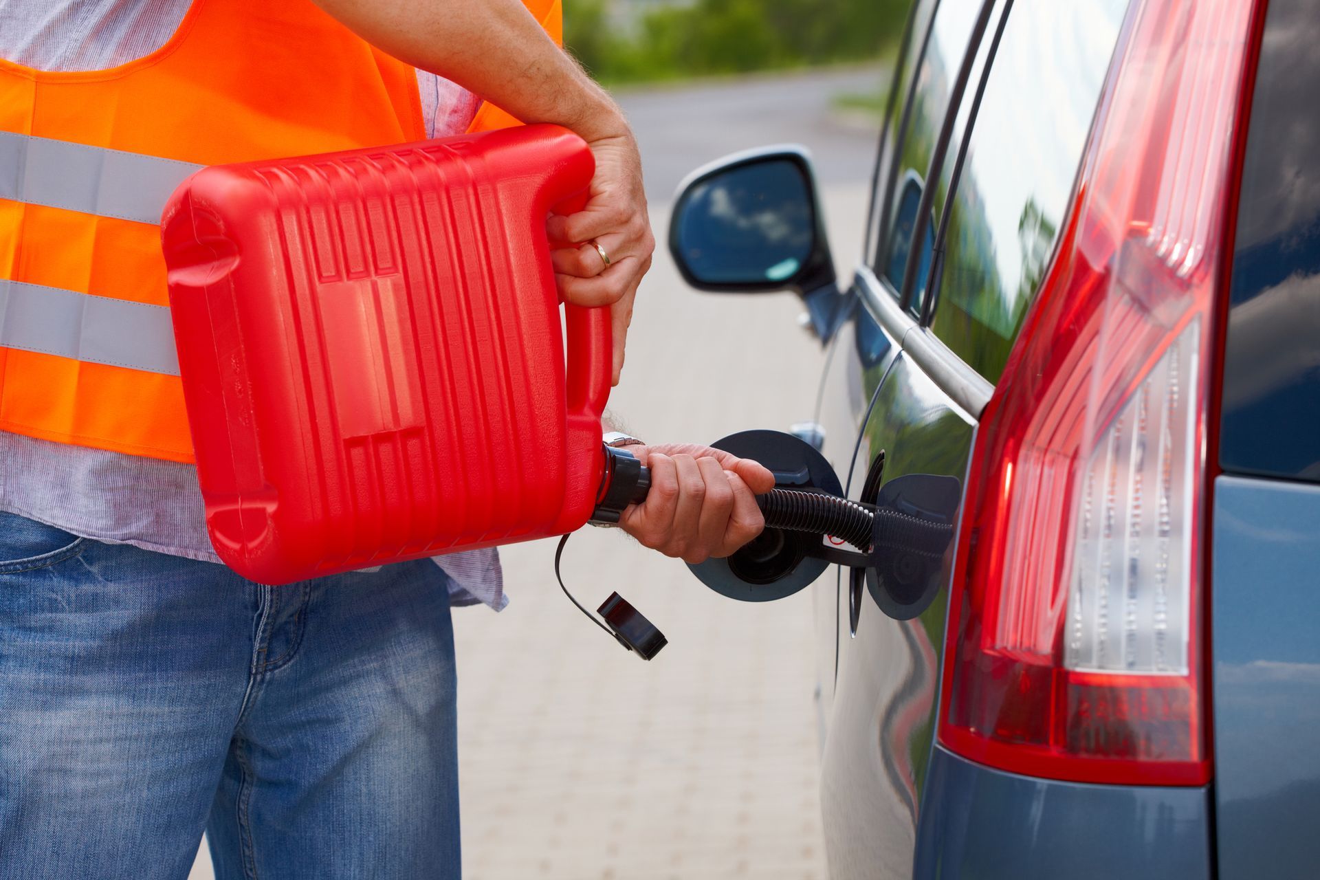 A man is pouring gas into a car.