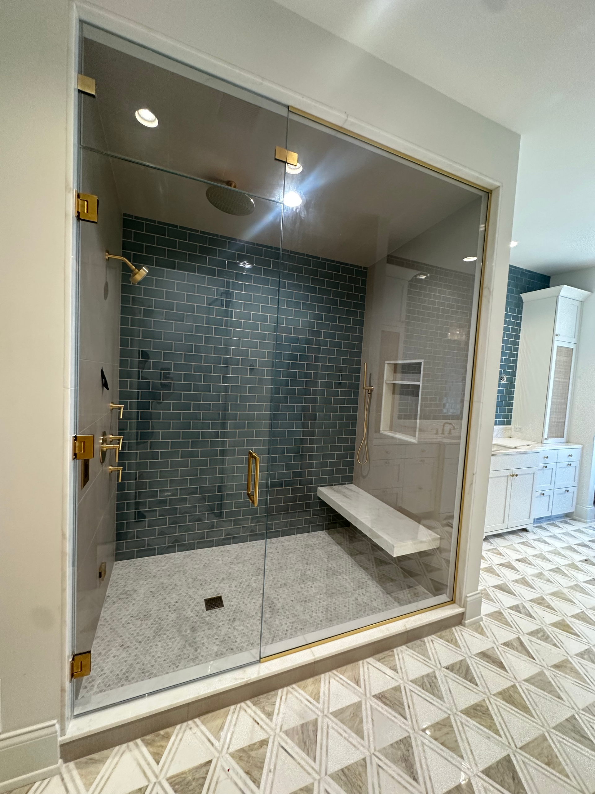 A bathroom with a walk in shower and a bench.