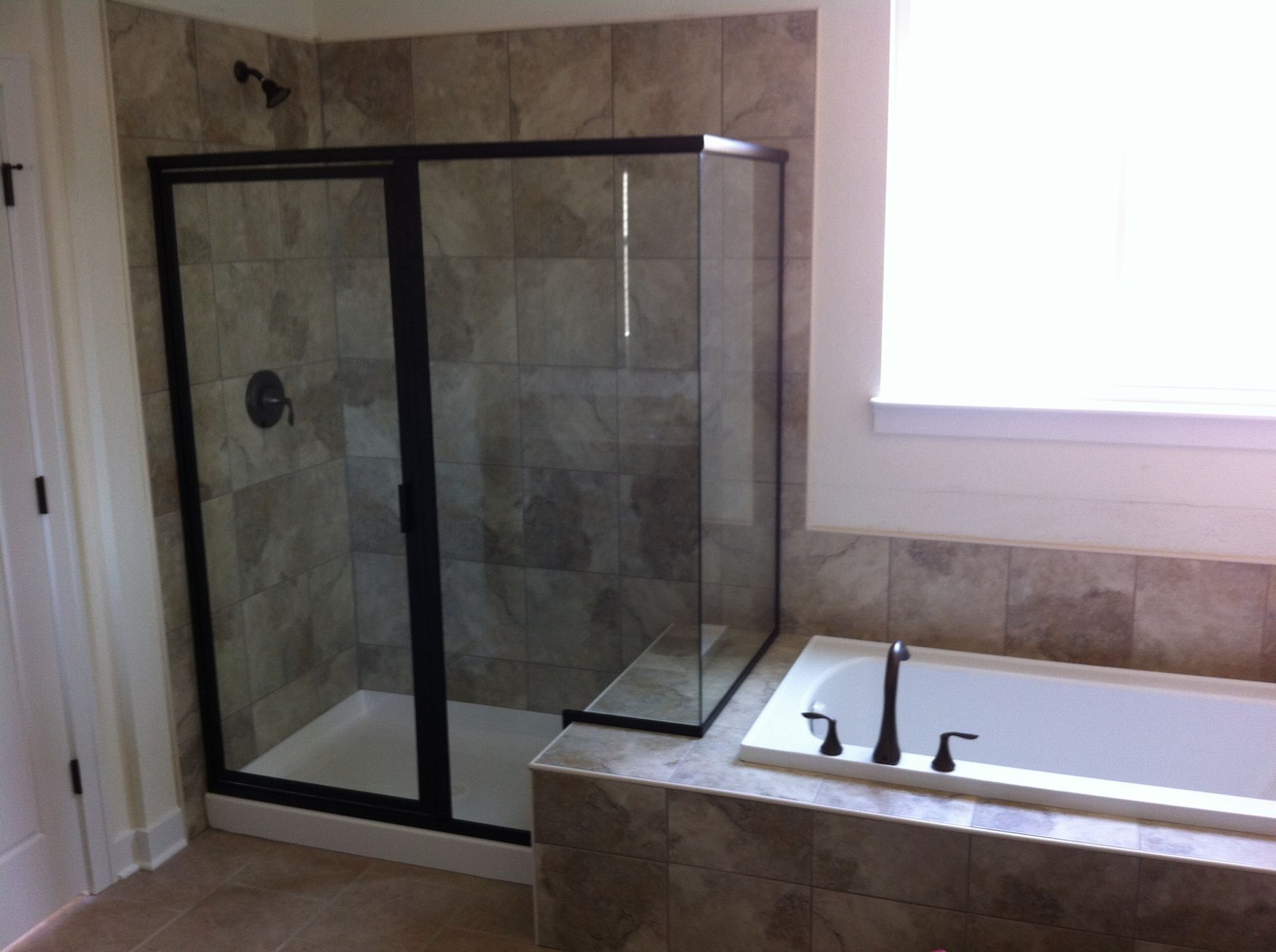 A bathroom with a tub a shower and a window