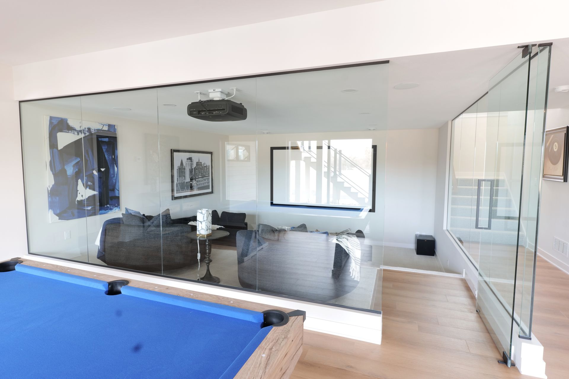 Two vanity mirrors with black frames, sconces, and fixtures on a marble countertop.