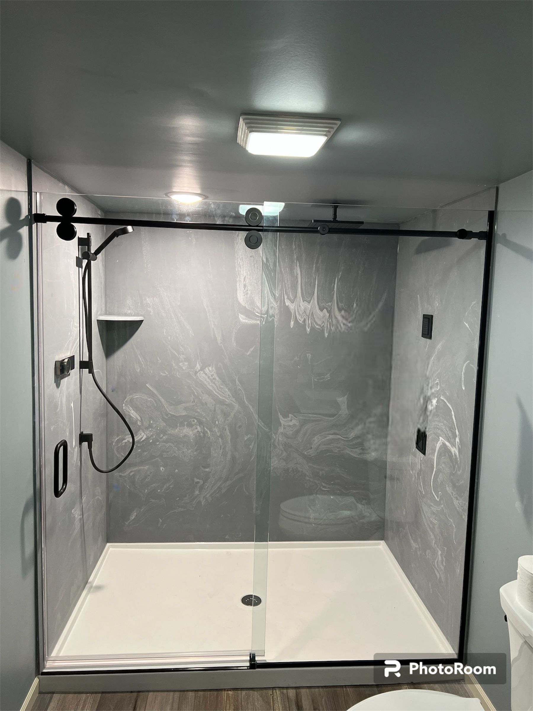 A bathroom with a walk in shower and a toilet.