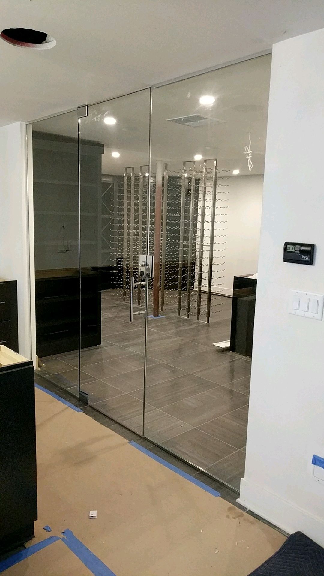 A room with a sliding glass door leading to a wine cellar.