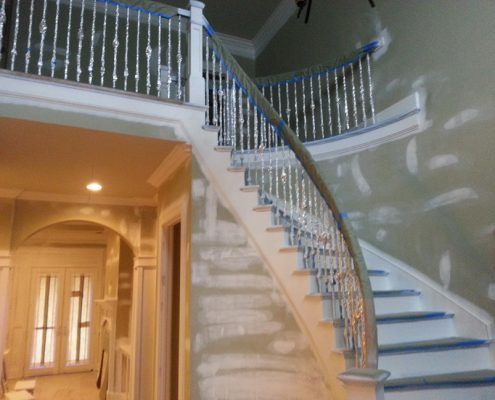 a curved staircase with blue steps is being painted in a house .