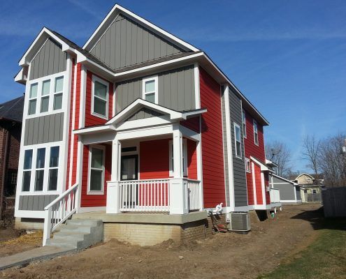 a red and gray house with a white porch