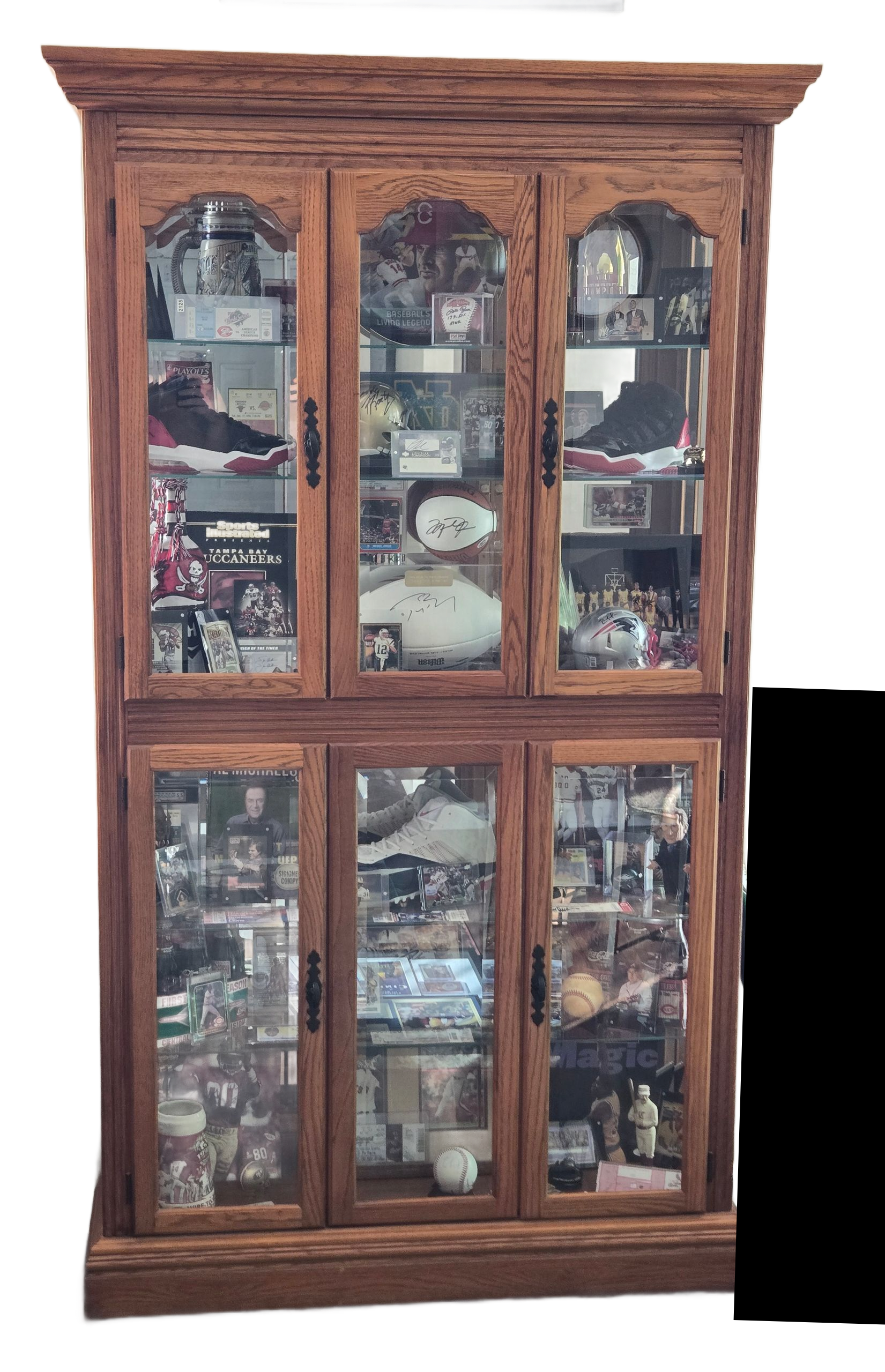 A wooden curio cabinet with glass doors and shelves filled with plates and other items.