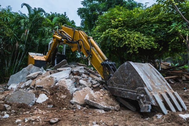 An excavator at work on land clearing and demolition at an active construction site. 