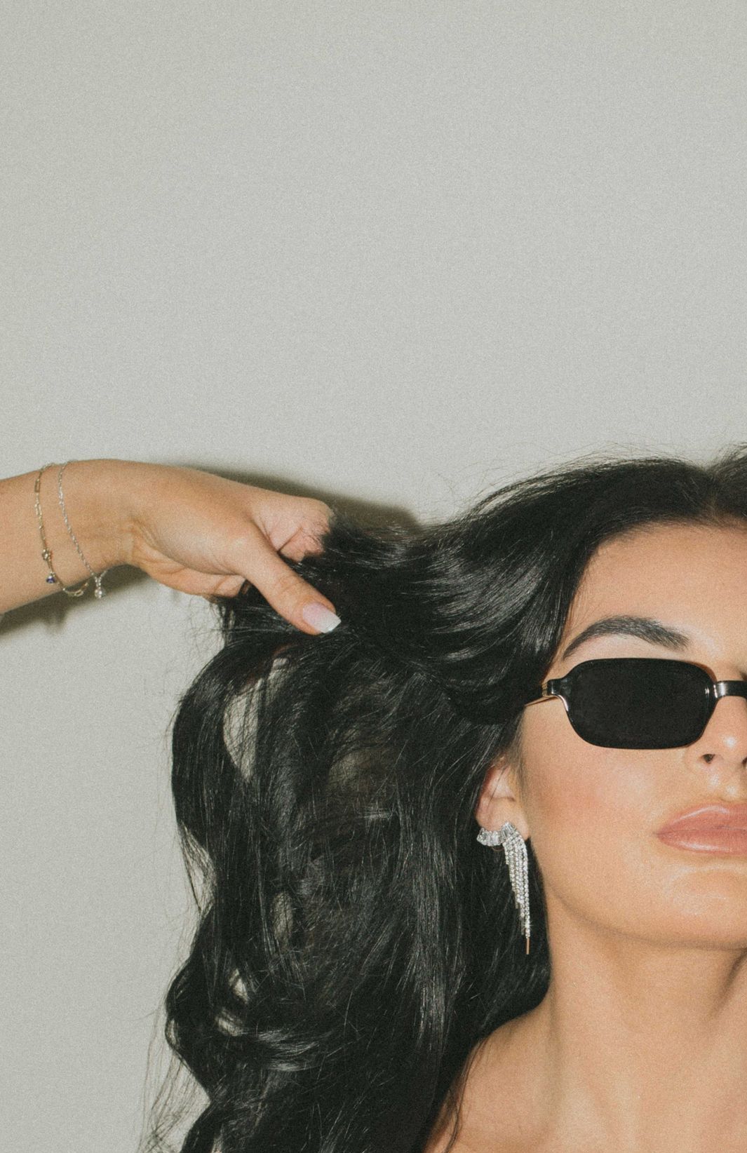 A woman is getting her hair curled with a curling iron