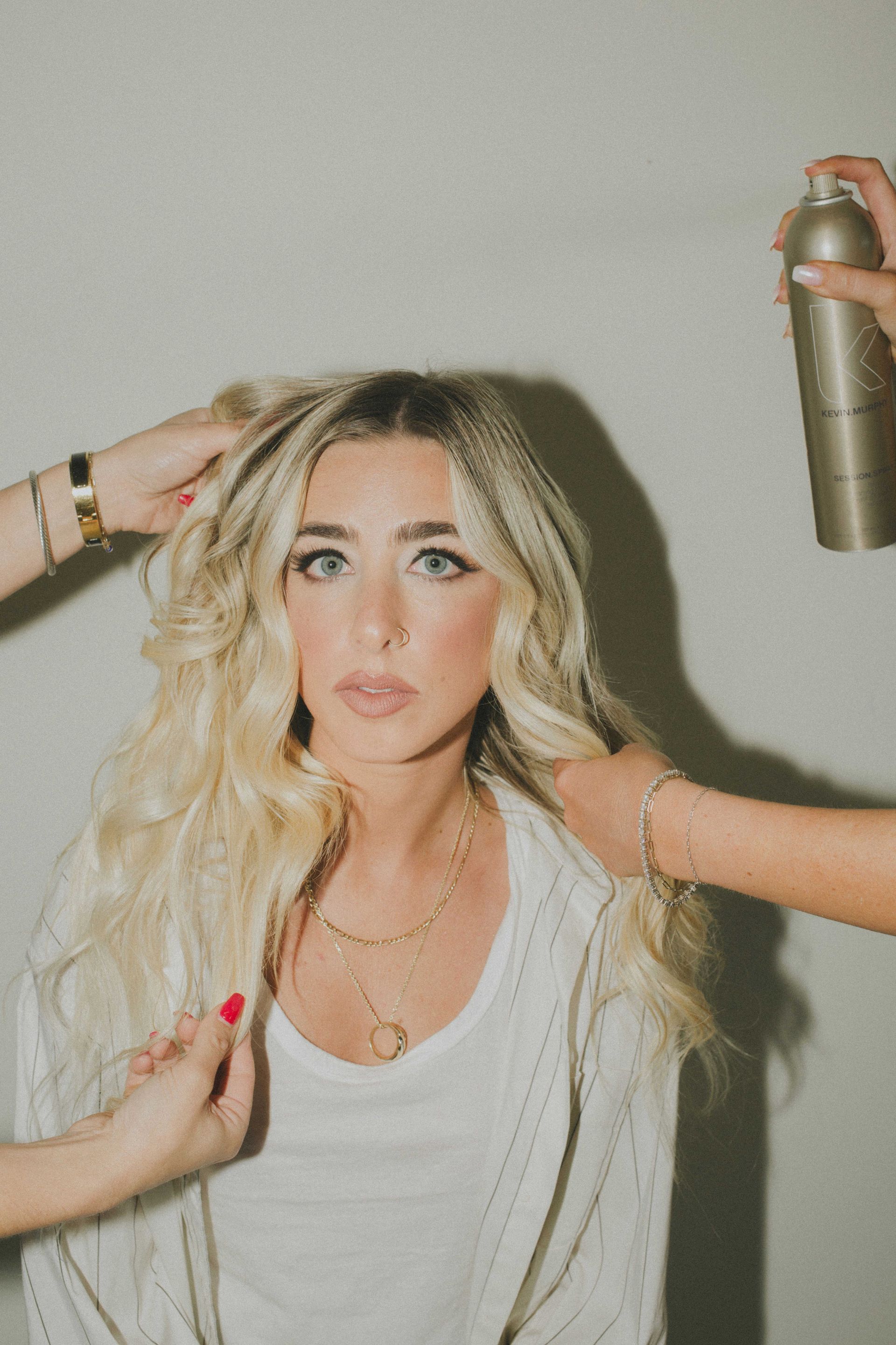 A woman is getting her hair done by a hairdresser.