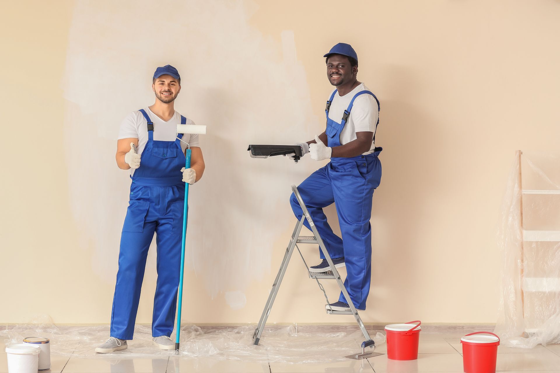 Two men are painting a wall in a room.