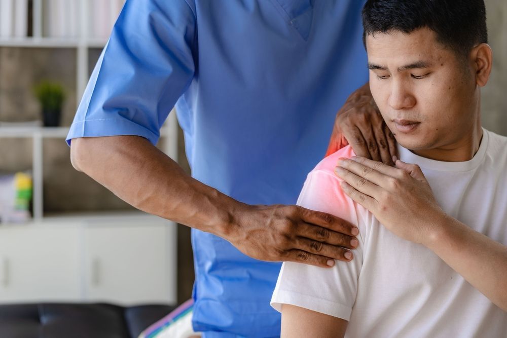 A physiotherapist stretching a patient's rotator cuff.