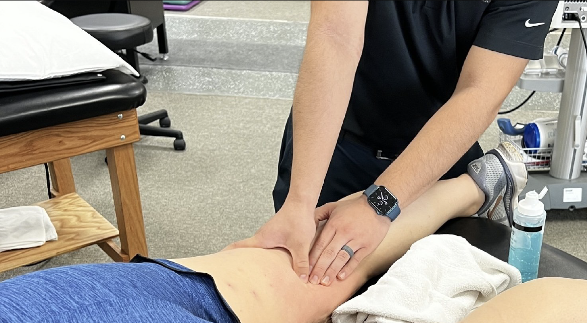 A man is giving a woman a massage on her leg.