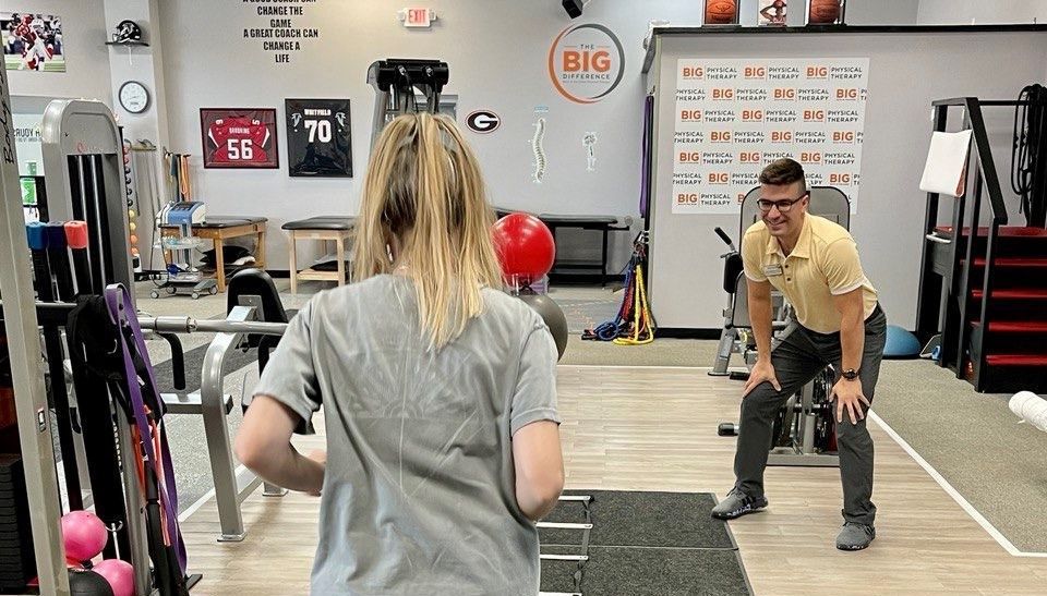 A physical therapist works with a young woman with blonde hair, she needs Physical Therapy for Sports Injuries