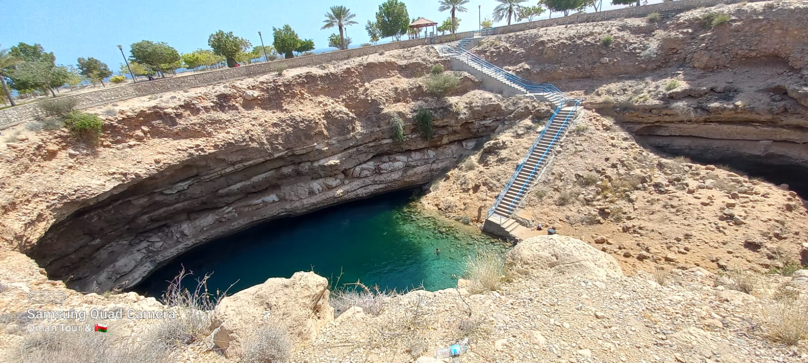 Omani local guide explaining cultural history near Nizwa Fort.
