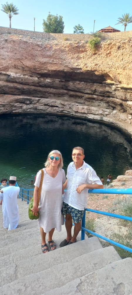 Camel caravan crossing golden sand dunes at sunset in the desert.