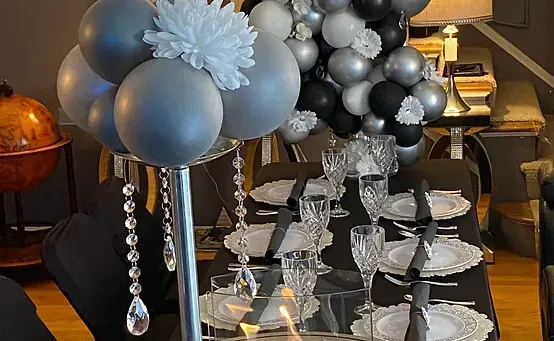 Silver, black, and white balloon and tiered dish display on a table.