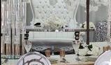 Elegant white wedding table setting with chair, floral arrangement, and glassware.